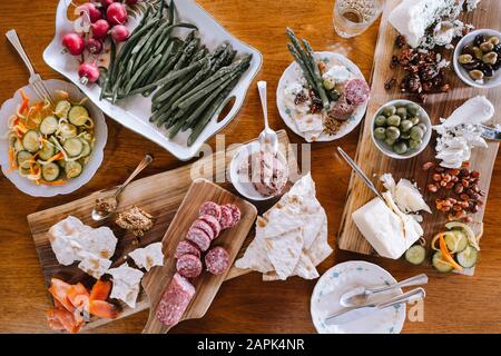 Spread of appetizers on wooden cutting boards and table. Stock Photo