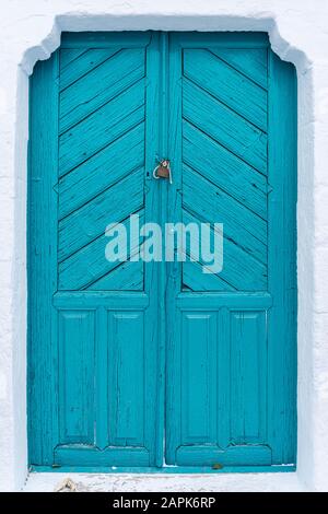 Turquoise wooden slatted door in Pyrgos Kallisits, Santorini, Greece Stock Photo