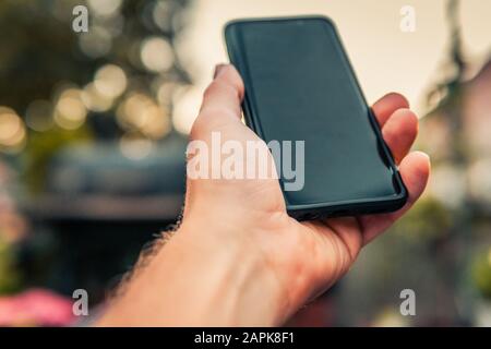 Male hand holding black smartphone Stock Photo