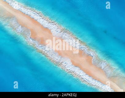 Aerial view of blue sea with waves on the both sides at sunset Stock Photo