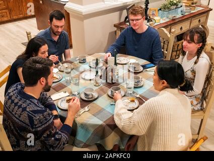 Family seated around Thanksgiving dinner table Stock Photo