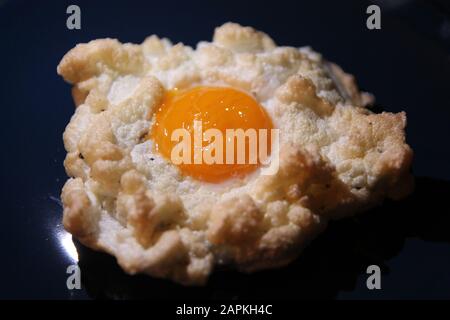 The whipped fried egg on a blue dish Stock Photo