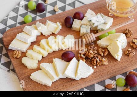 Assorted cheeses on the board. Stock Photo