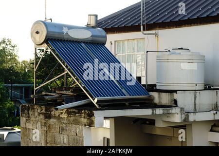 Mauritius, December 2019 - Solar panel and water tanks on top of a house in a developing rural area  Stock Photo