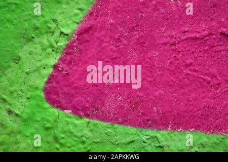 The abstract pattern on the wall is painted in juicy pink and green. Background. Stock Photo