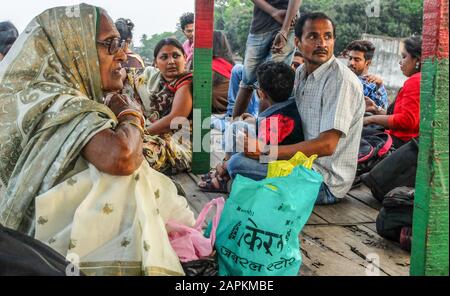 KOLKATA,WEST BENGAL/INDIA-MARCH 22 2018:River boat passengers on the Hooghly river sit on the small wooden deck as they travel downstream towards Belu Stock Photo