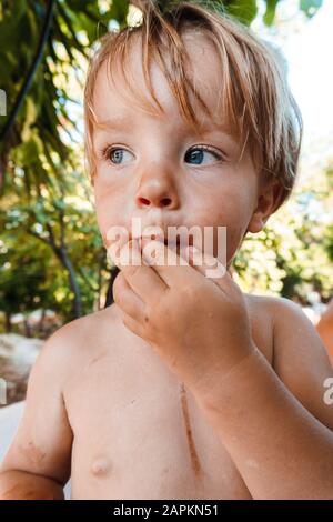 Little boy eating a berry Stock Photo