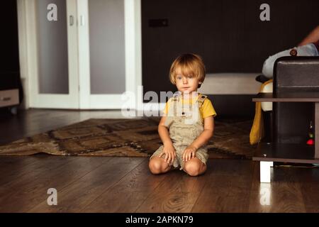 Little boy sitting on the carpet in the house Stock Photo