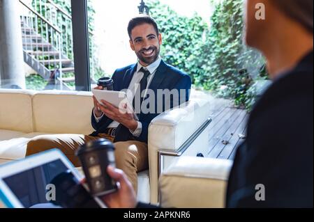 Smiling businessman looking at colleague in lounge Stock Photo