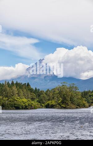 New Zealand, Scenic view of green forest surrounding Lake Mangamahoe with Mount Taranaki looming in background Stock Photo