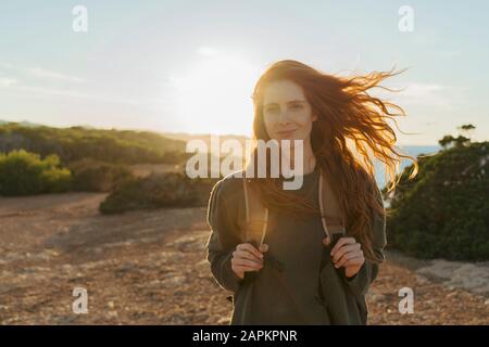 Portrait of redheaded young woman at the coast at sunset, Ibiza, Spain Stock Photo
