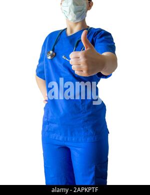 Young caucasian female doctor wearing a blue medical uniform and a mask showing a thumbs-up Stock Photo