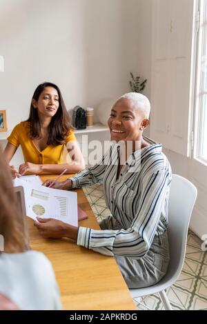 Happy businesswomen having a meeting in office Stock Photo