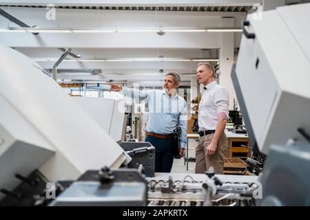 Two colleagues talking in a factory Stock Photo