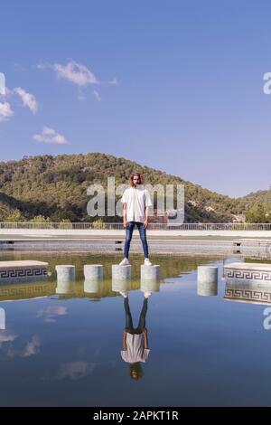 Bearded young man standing on bollards Stock Photo