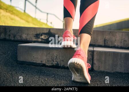Legs of woman running in the city, rear view Stock Photo