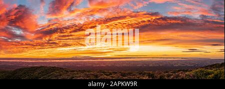 New Zealand, Dramatic sunrise over Tongariro National Park with silhouettes of volcanoes in distance Stock Photo