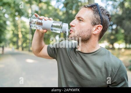 Man drinking water after workout outdoors Stock Photo