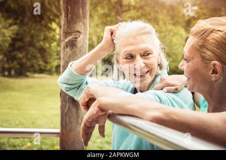 Senior woman and mature woman during workout on high bar Stock Photo