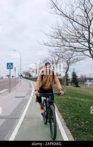 Portrait of smiling young man riding bicycle in the city Stock Photo