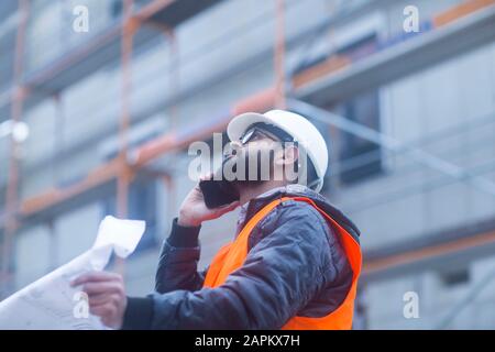 Construction engineer on the phone at construction site Stock Photo