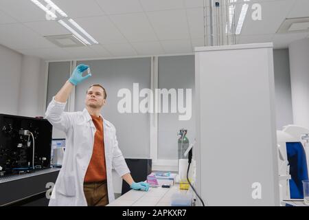 Scientist analyzing a specimen in laboratory Stock Photo