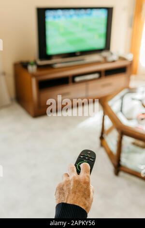 Hand of senior man using remote control Stock Photo
