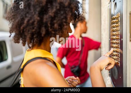 Young woman ringing the bell in the city Stock Photo