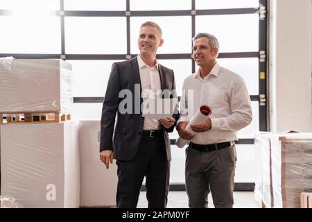 Two confident businessmen with papers in a factory Stock Photo
