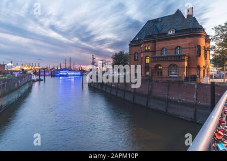 Germany, Hamburg, Police station at edge of Elbe river canal with harbor in background Stock Photo