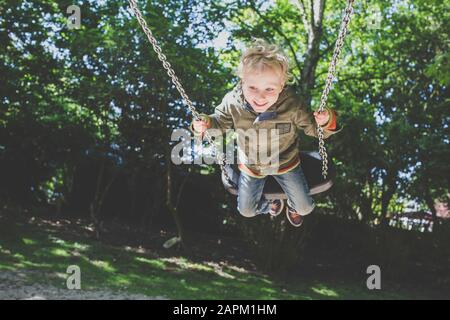 Happy little boy on a swing Stock Photo