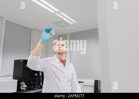 Scientist analyzing a specimen in laboratory Stock Photo