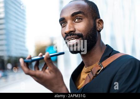 Portrait of young businessman using cell phone outdoors Stock Photo