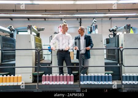 Two businessmen talking in a printing shop Stock Photo
