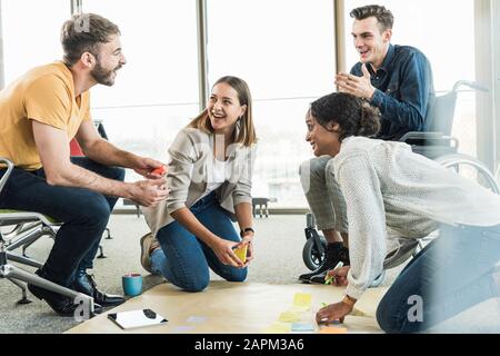 Happy young business people working together on a project in office Stock Photo