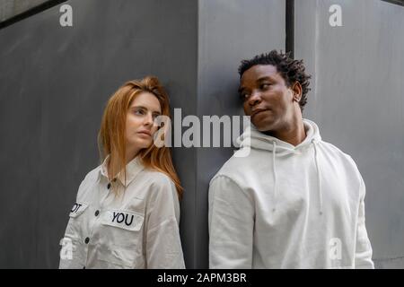 Portrait of a couple leaning on a wall Stock Photo