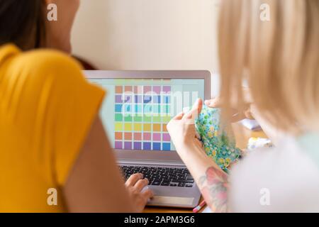 Fashion designers working with laptop and color samples Stock Photo