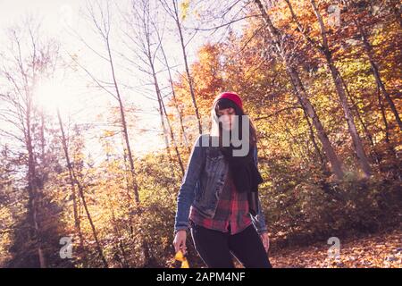 Woman wearing red woolly hat and denim jacket Stock Photo