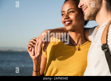 Affectionate young couple embacing at the waterfront, Lisbon, Portugal Stock Photo
