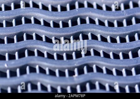 Close-up of a gray solid plastic geometric texture that forms undulations in the horizontal and vertically square cells Stock Photo