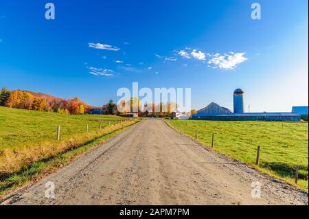 Dirt road leading to a farm an a blue sky day in Stowe Vermont USA Stock Photo