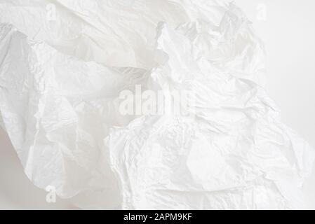 A close-up shot of crumpled delicate white tissue paper set on white background. Stock Photo