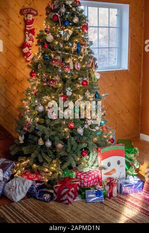 family Christmas tree with presents underneath on Christmas morning Stock Photo