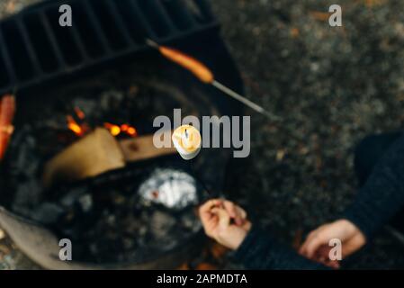 Marshmallow on skewers is fried at the stake. Toasted marshmallows open flame on skewer Stock Photo