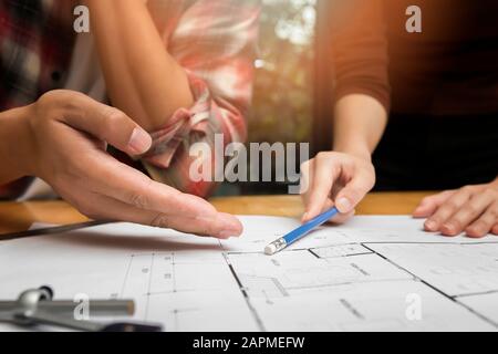 Group of two coworkers working with blueprint in office. co-working teamwork concept. Stock Photo