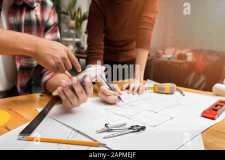 Group of two coworkers working with blueprint in office. co-working teamwork concept. Stock Photo