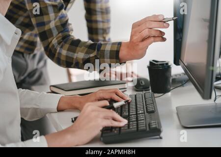 Young startup Programmers Sitting At Desks Working On Computers screen for Developing programming and coding to find solution to problem on New Applic Stock Photo