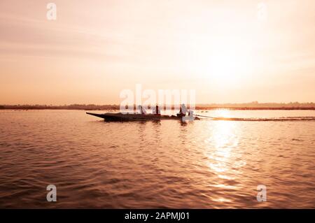 JAN 13, 2019 Udonthani, Thailand - Thai long tail boat with tourist in peaceful Nong Harn lake, Udonthani - Thailand. Wooden boat under warm beautiful Stock Photo