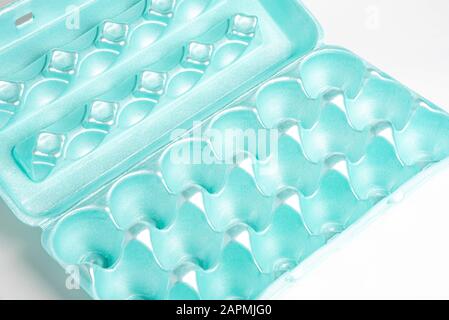 A close-up shot of an empty and used polystyrene egg carton set on a plain neutral background. Stock Photo