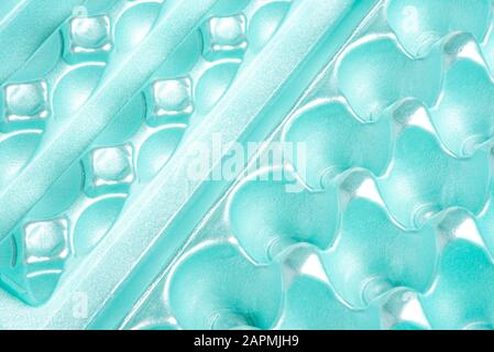 A close-up shot of an empty and used polystyrene egg carton set on a plain neutral background. Stock Photo